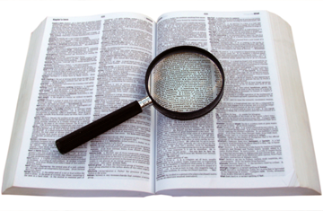 Magnifying glass focused on crossword clue in dictionary